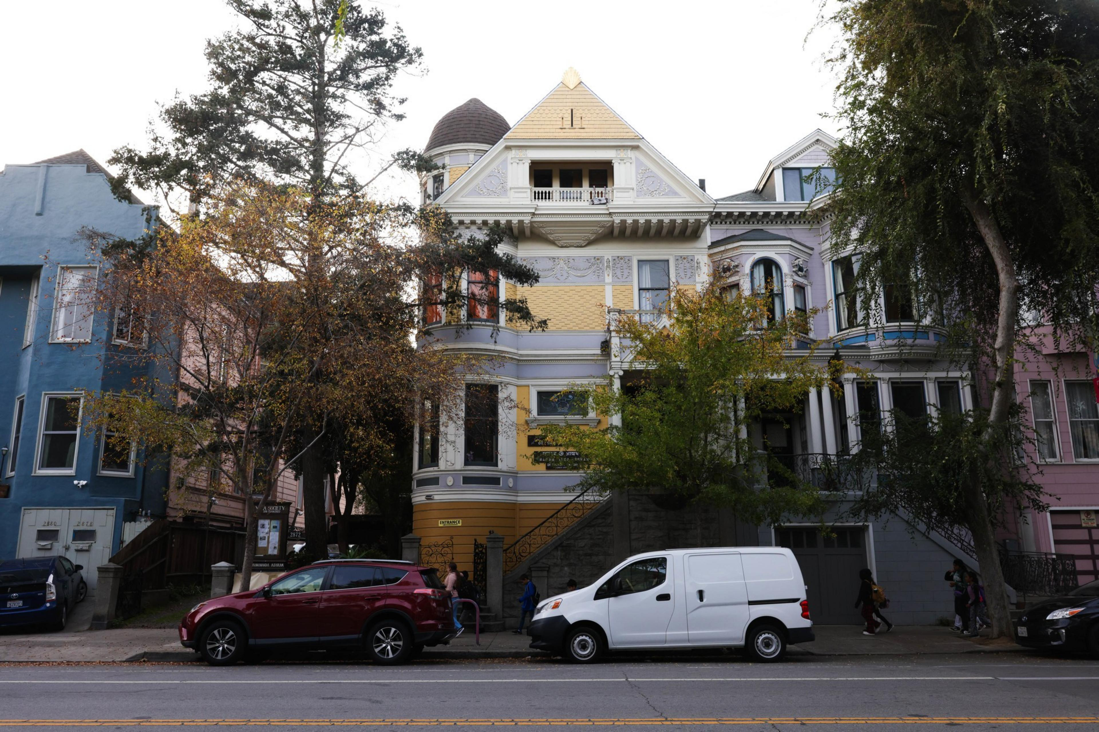 The exteriors of a Victorian era homes along a citystreet.