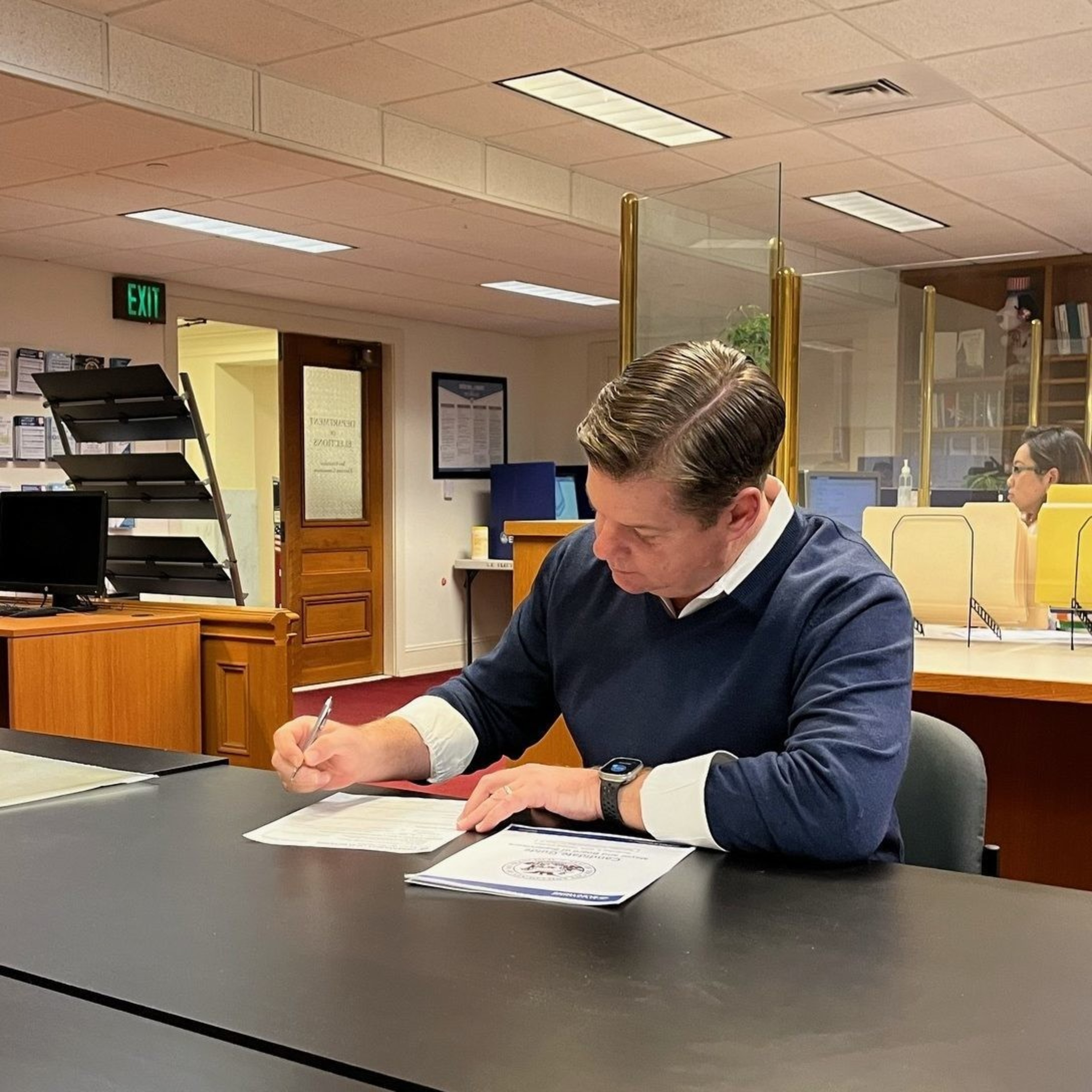 Mark Farrell fills out paperwork.