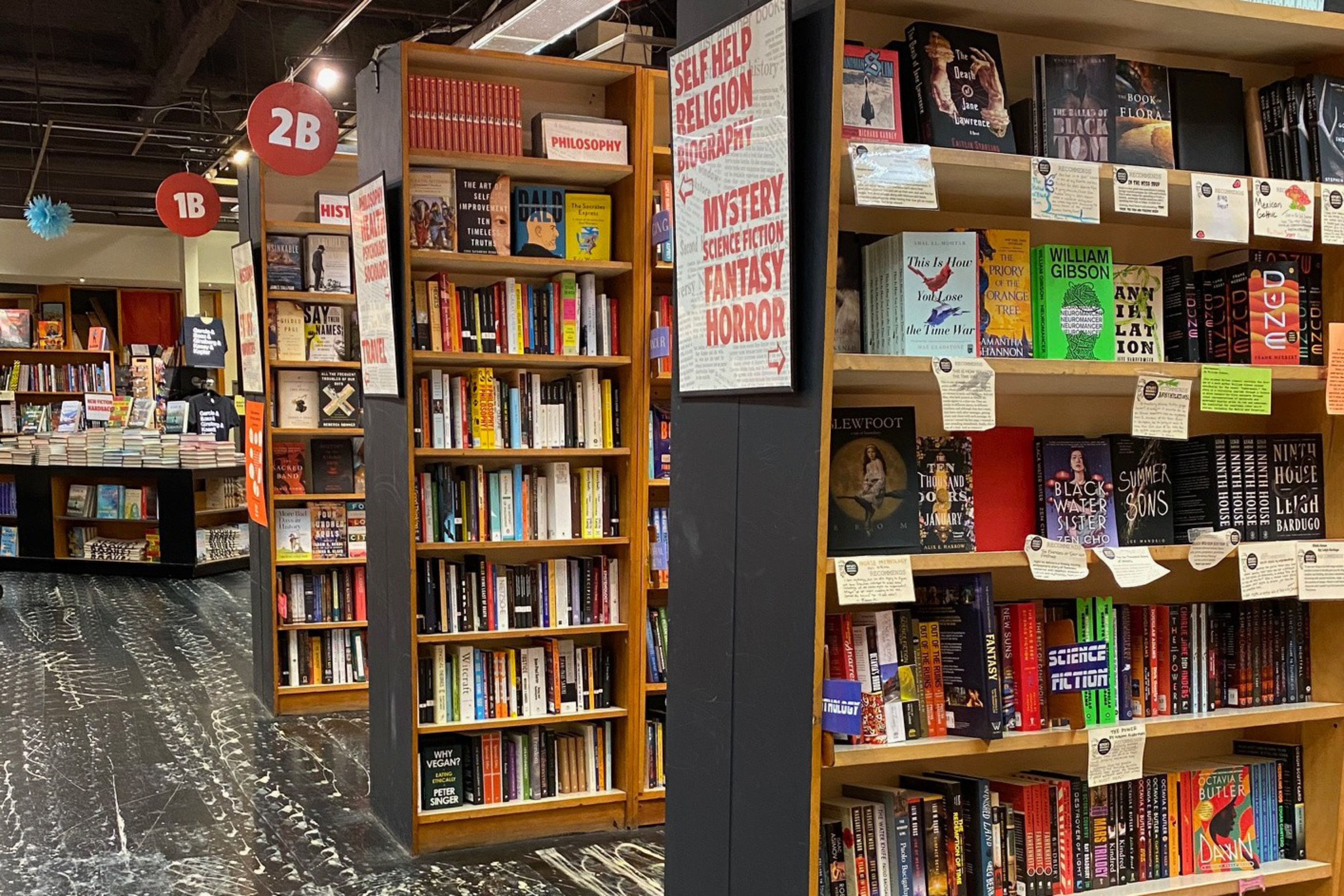 Stacks of books in rows of shelves. 