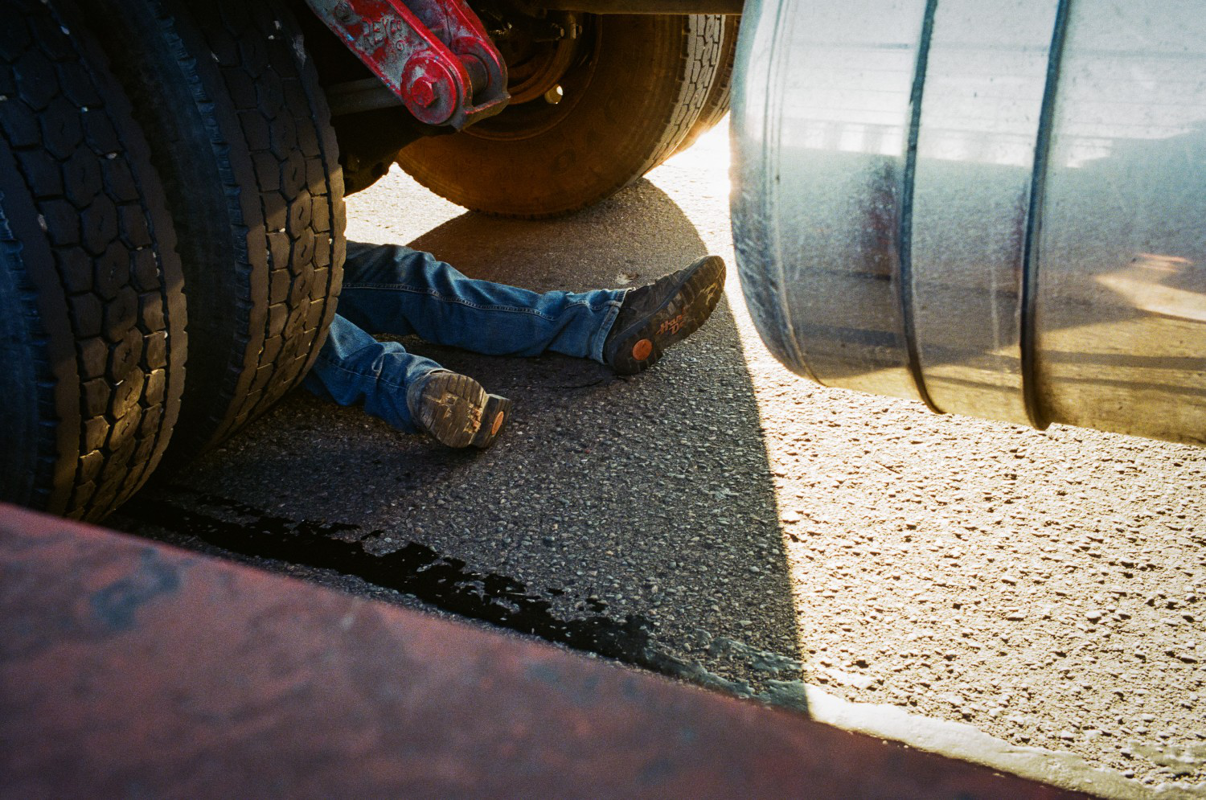 A truck driver works to unlock the rear axle of his vehicle on the bridge in September 2020.