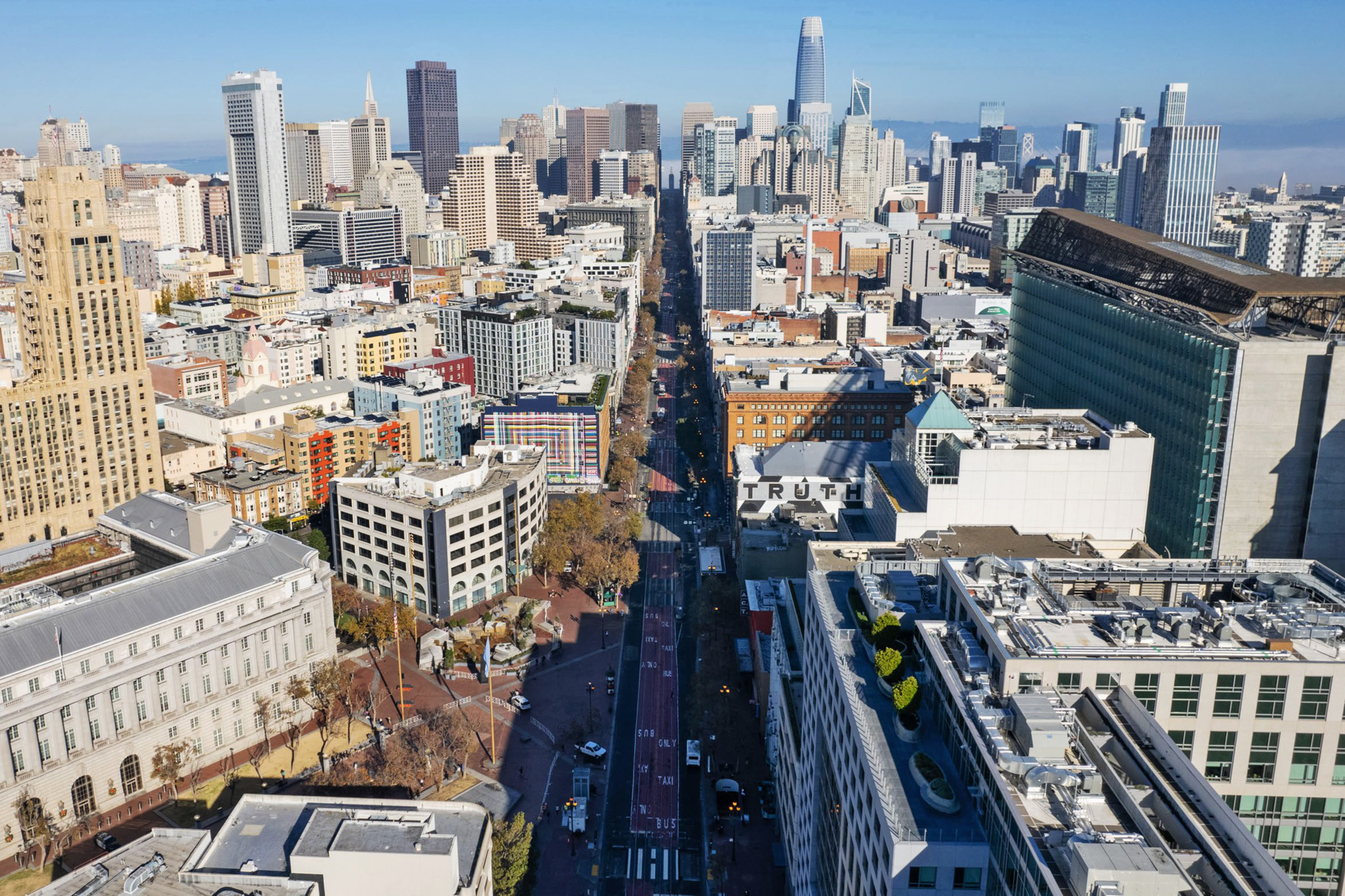 Aerial view of a dense urban cityscape with a mix of high-rise buildings and a clear sky.