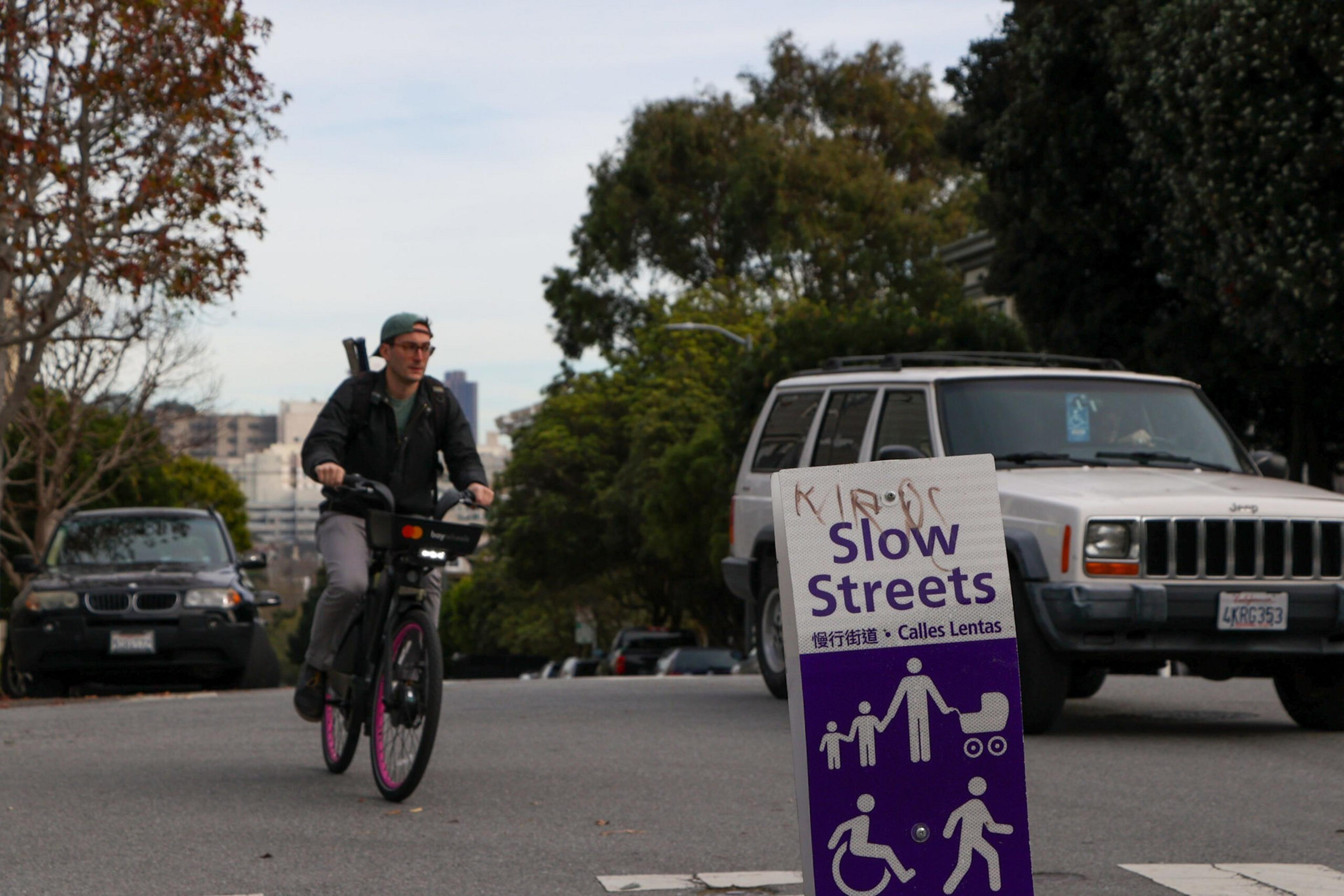 A biker rides down a street.