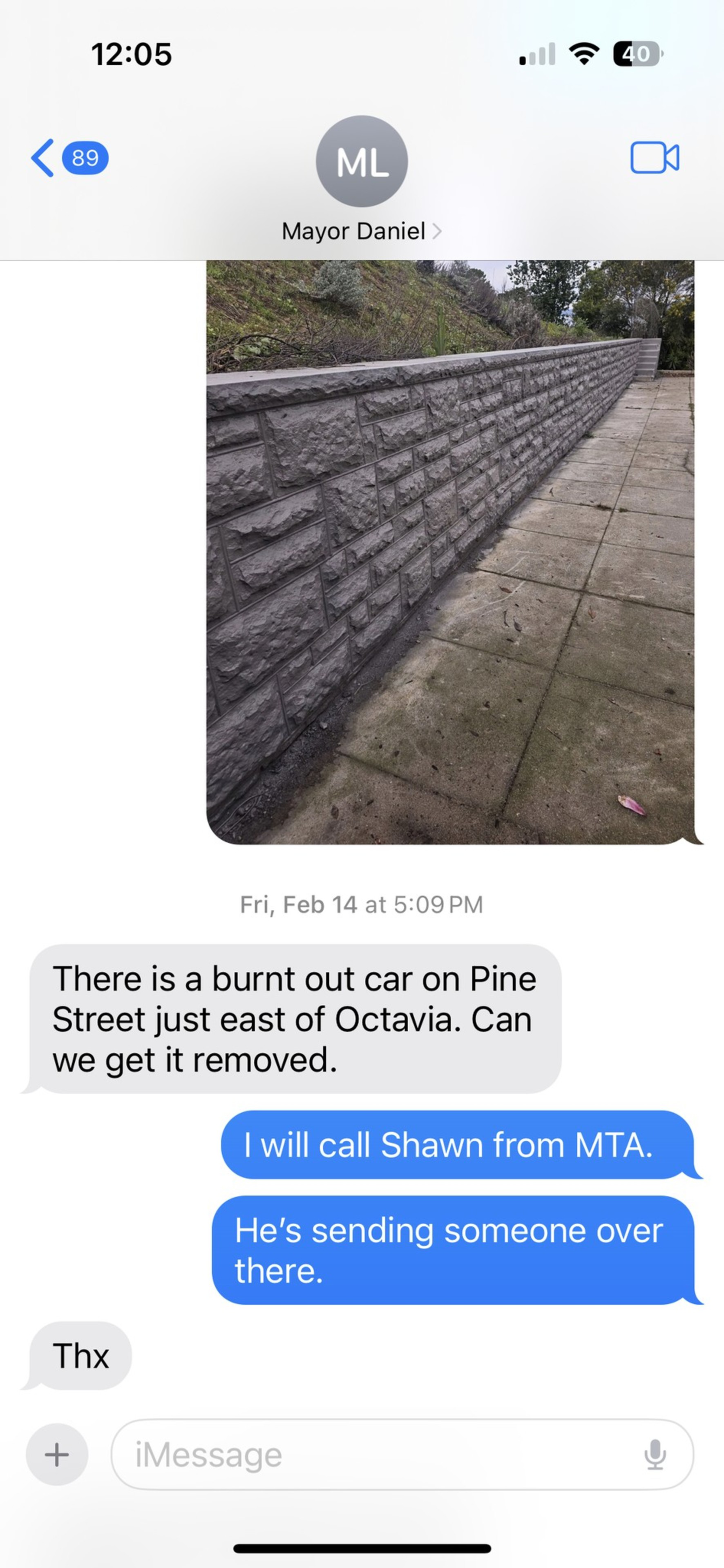 The image shows a text conversation about a burnt-out car on Pine Street. A reply confirms Shawn from MTA is sending someone to handle it.