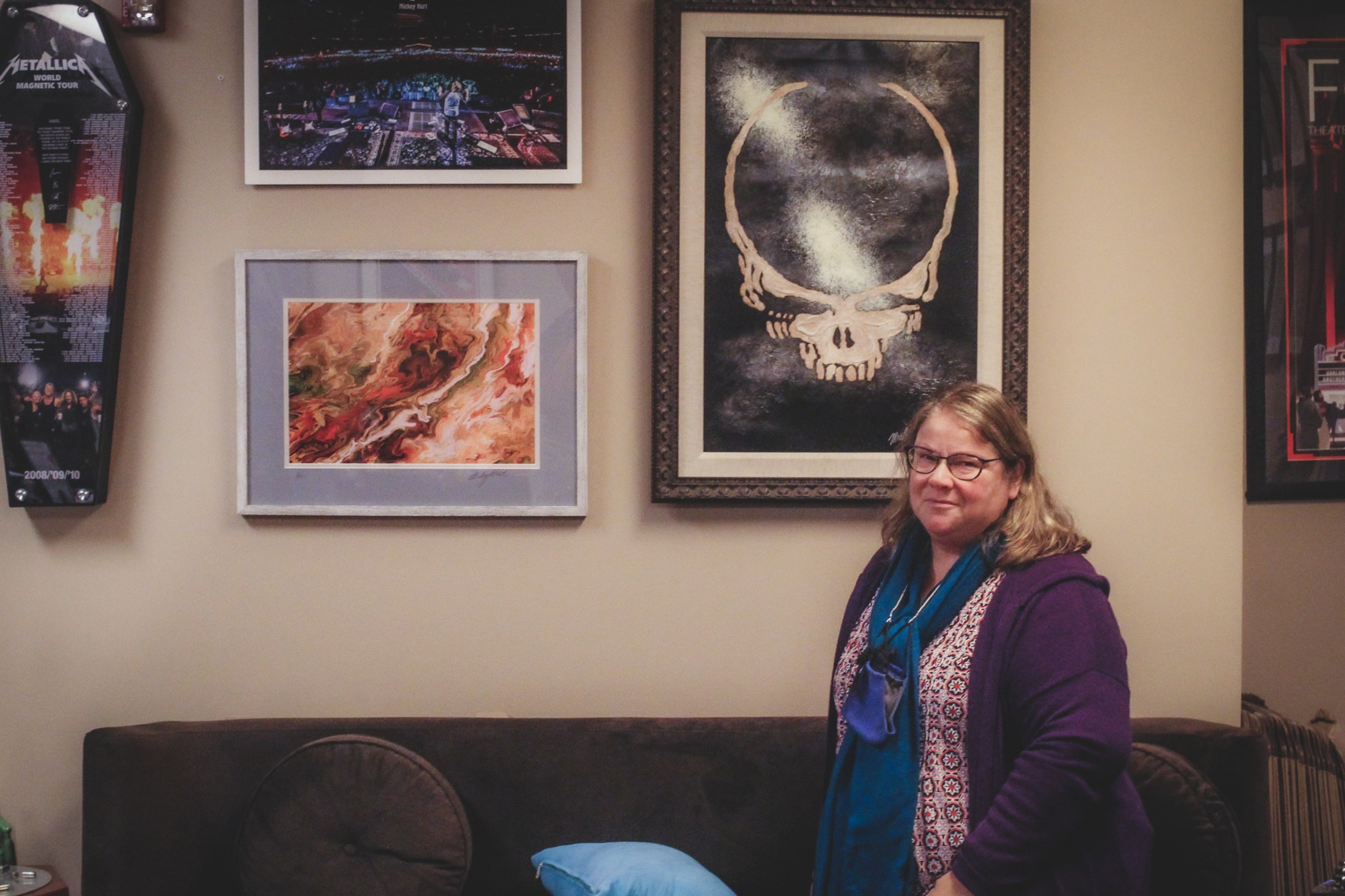 A woman standing in a room with posters on the wall.