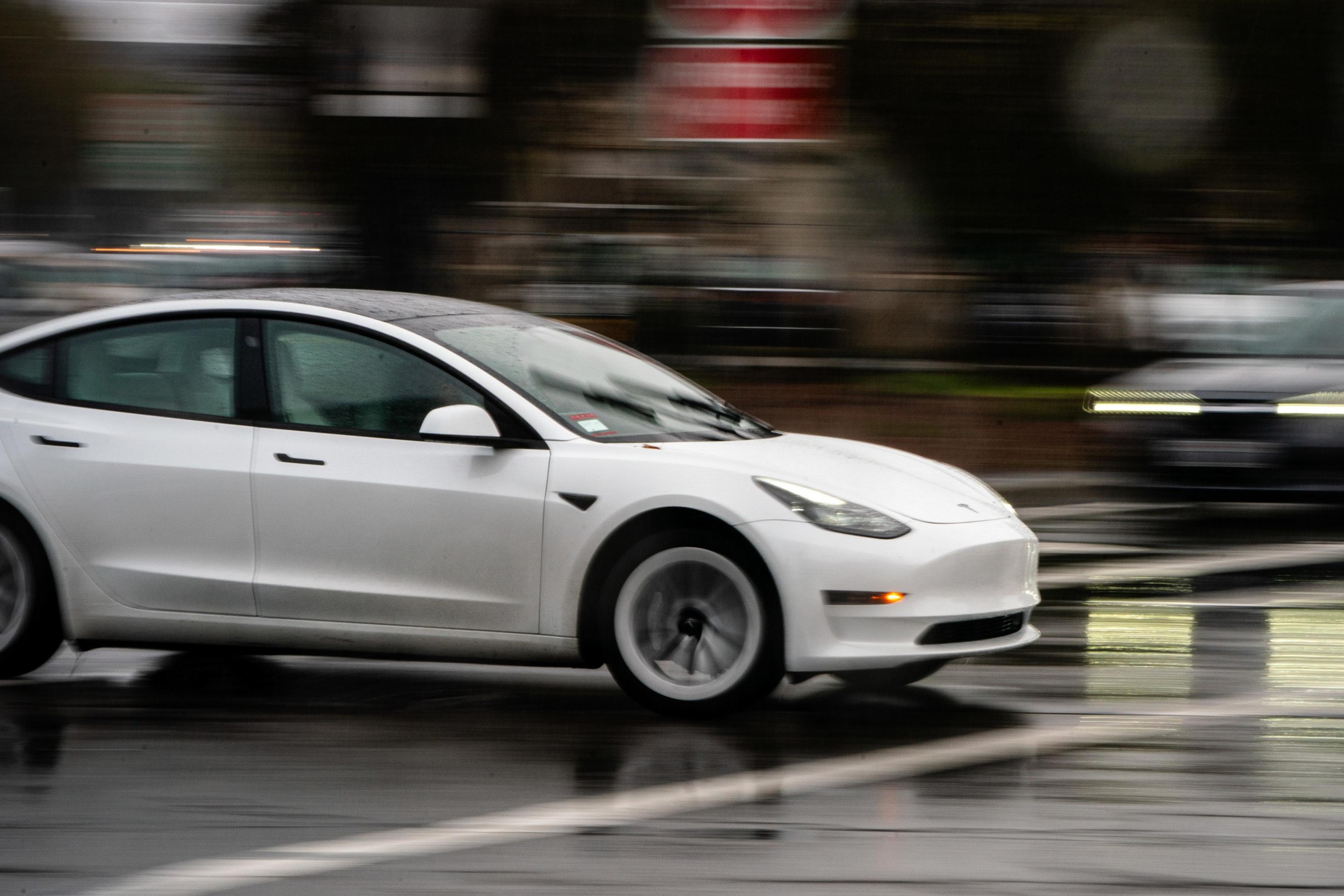 A white Tesla Model 3 with no front license plate.