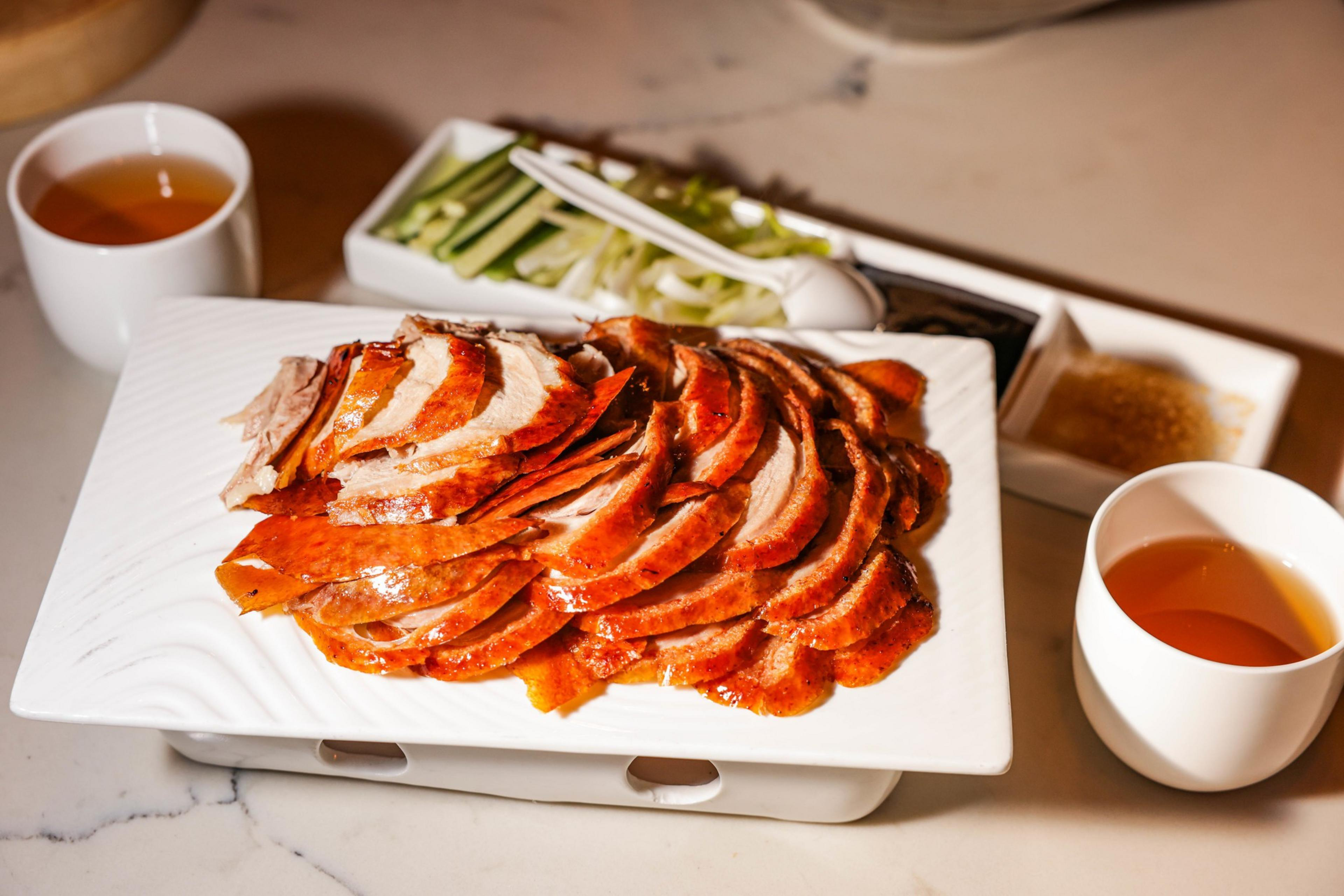 A plate of duck meat and other food on the table