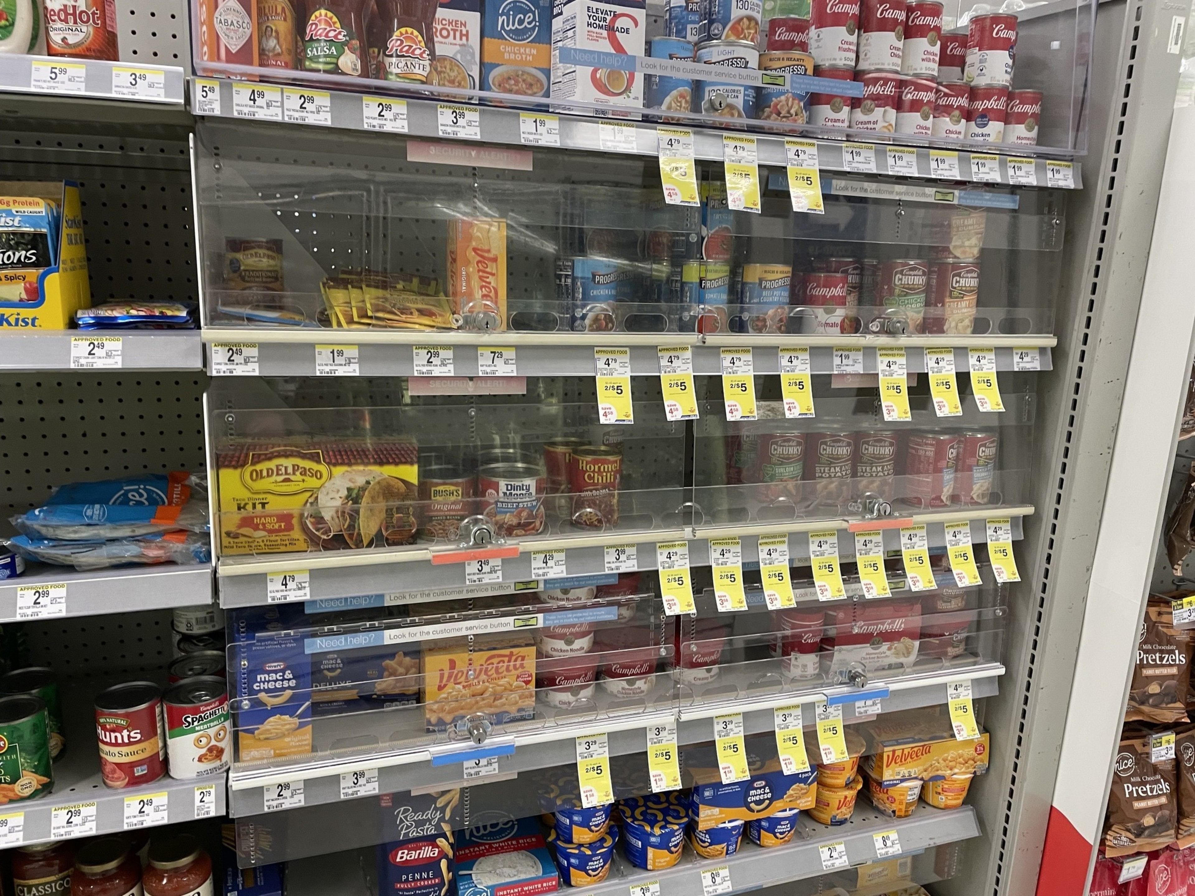 Cans of soup and chili sit behind locked plexiglass.