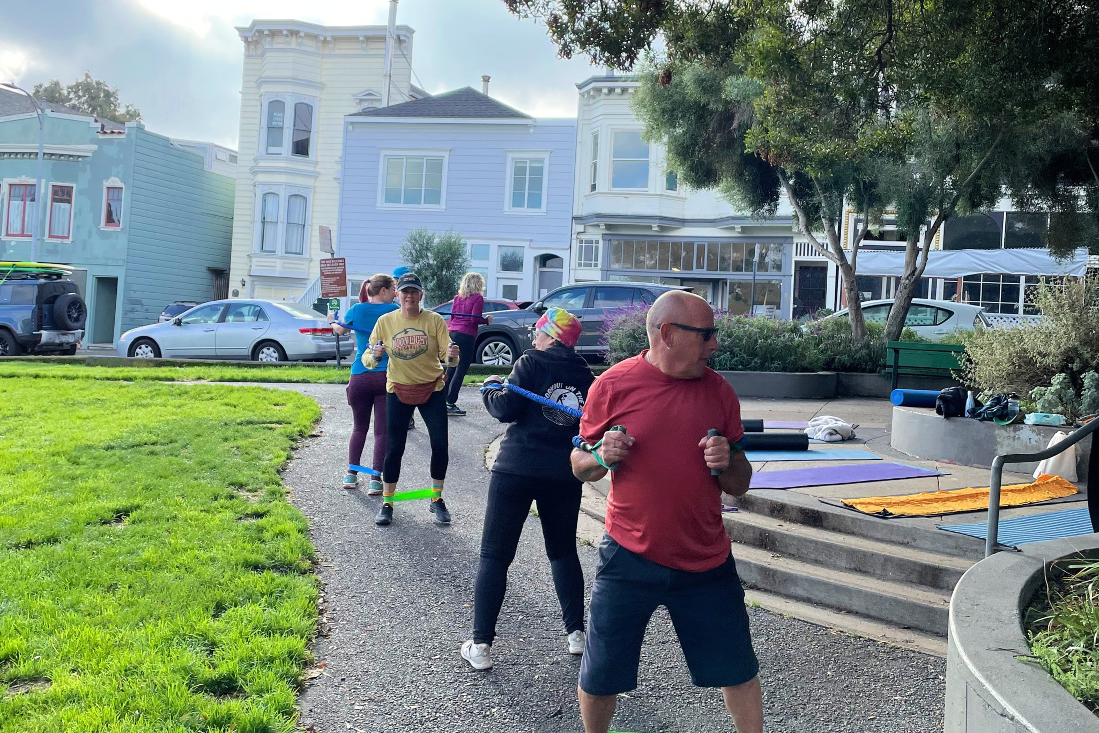 A line of people exercise in park in San Francisco. 