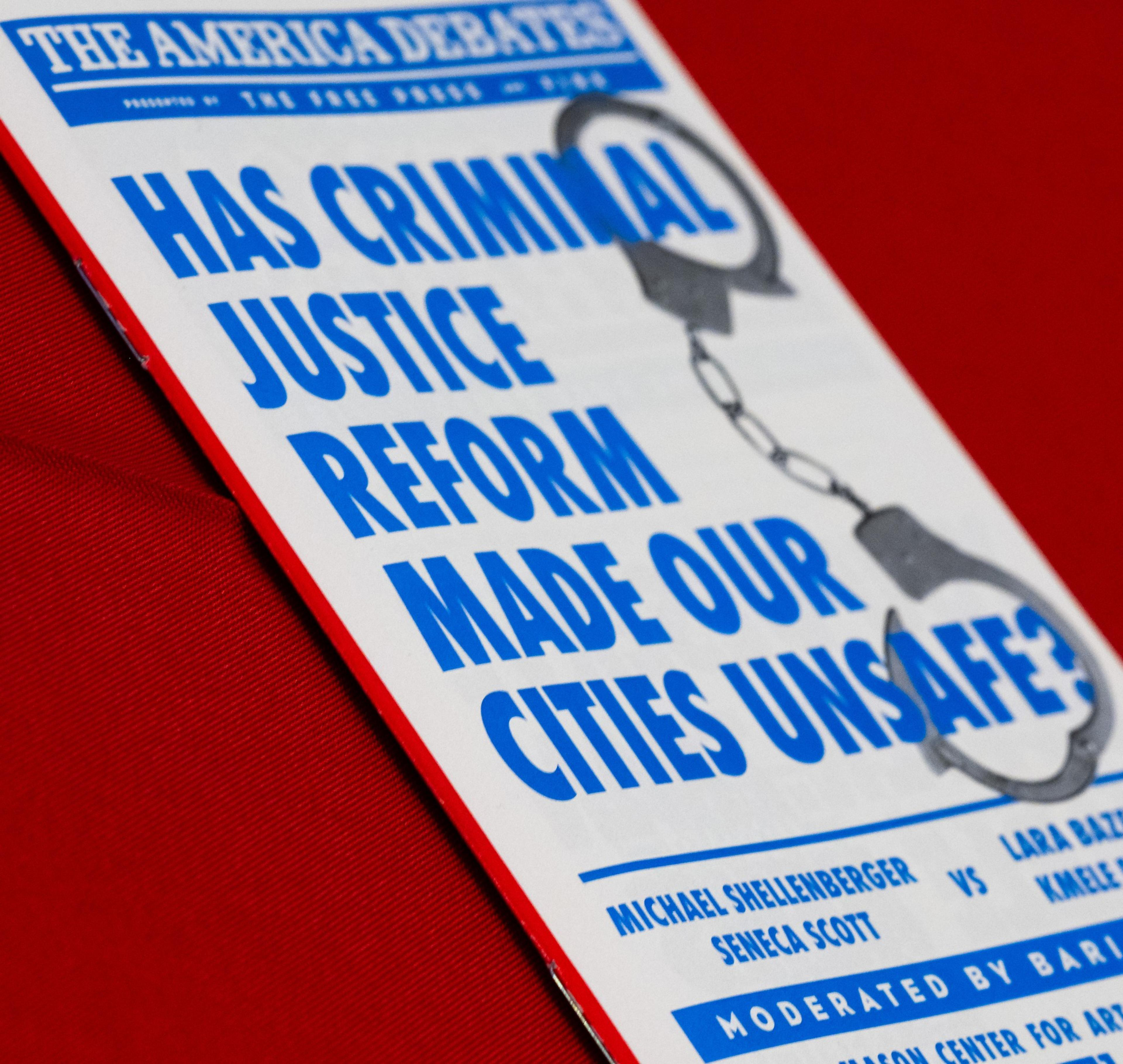 The image shows a debate flyer with blue text on a white background asking, &quot;Has criminal justice reform made our cities unsafe?&quot; with an image of handcuffs.