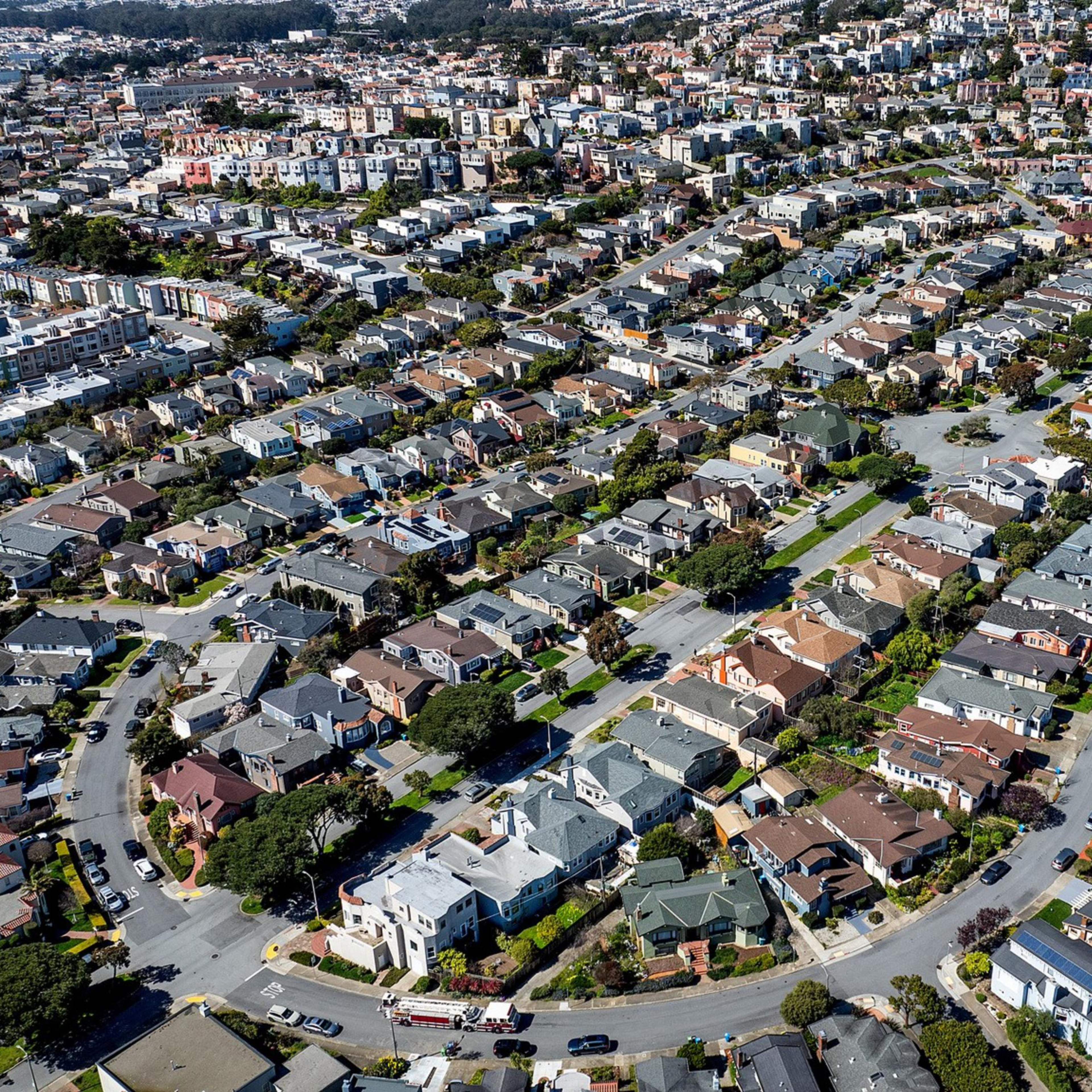 Aerial view of a dense residential area with rows of houses and intersecting streets.