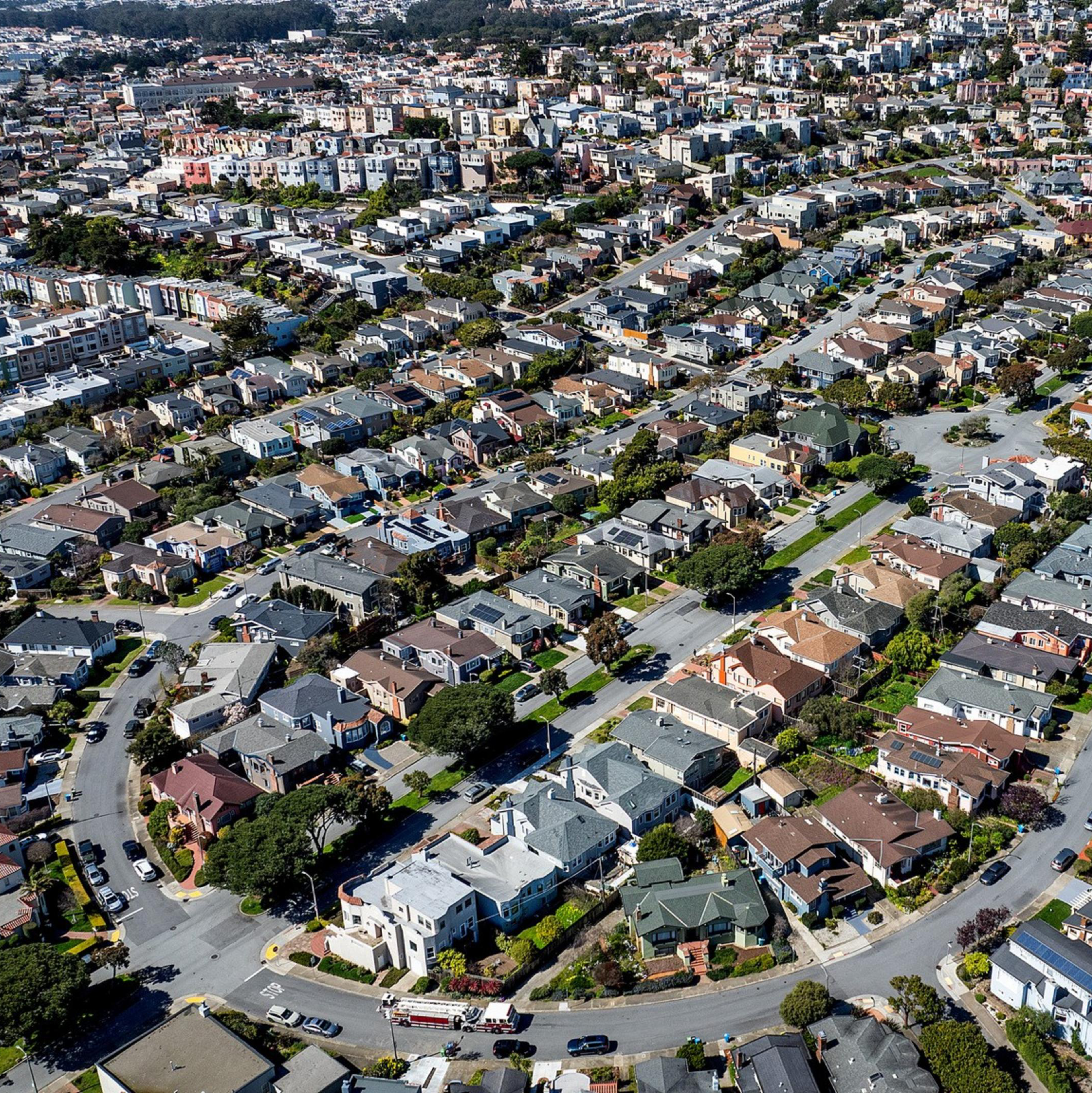 Aerial view of a dense residential area with rows of houses and intersecting streets.