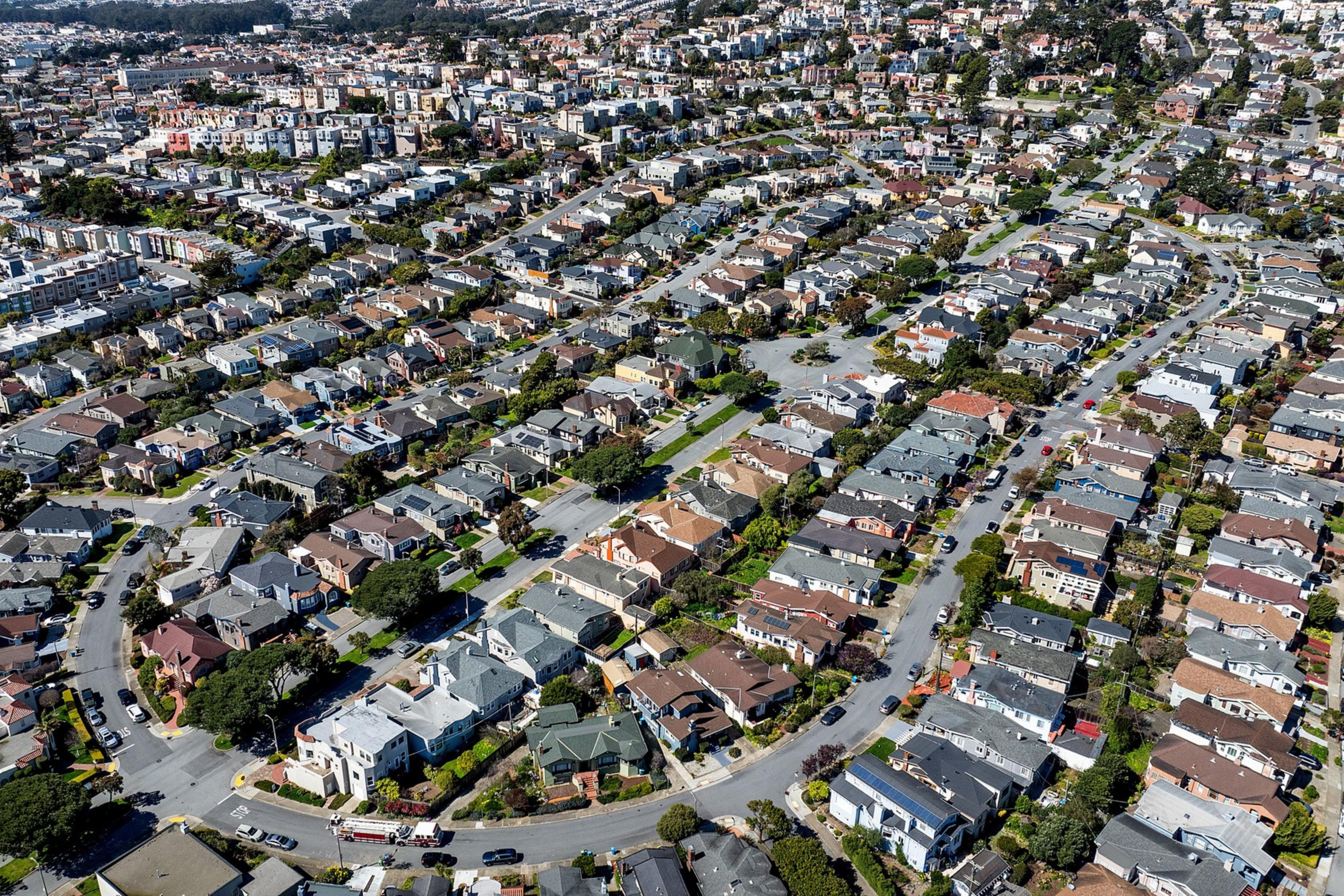 Aerial view of a dense residential area with rows of houses and intersecting streets.