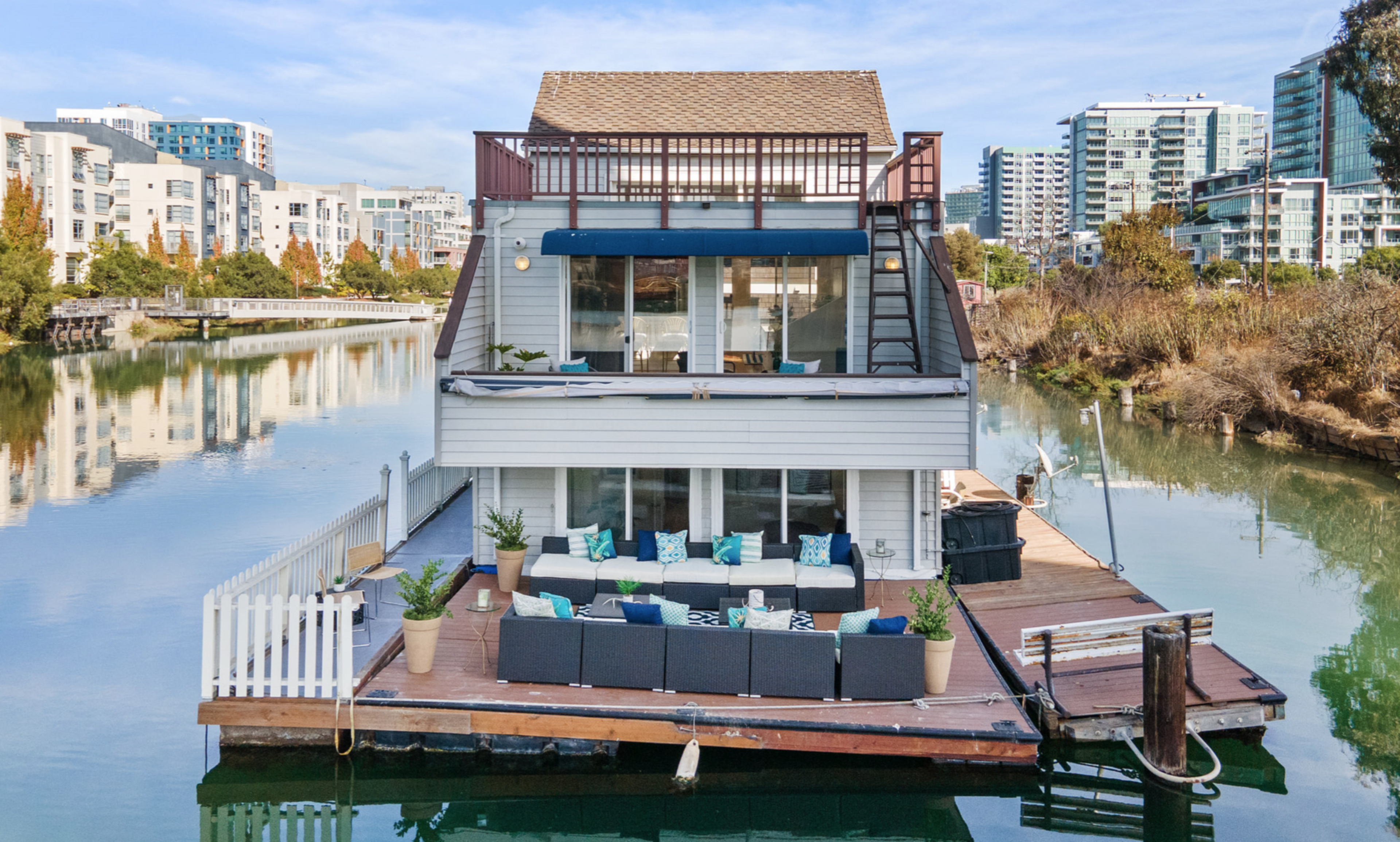 Plants and chairs adorn the deck of a houseboat on Mission Creek.