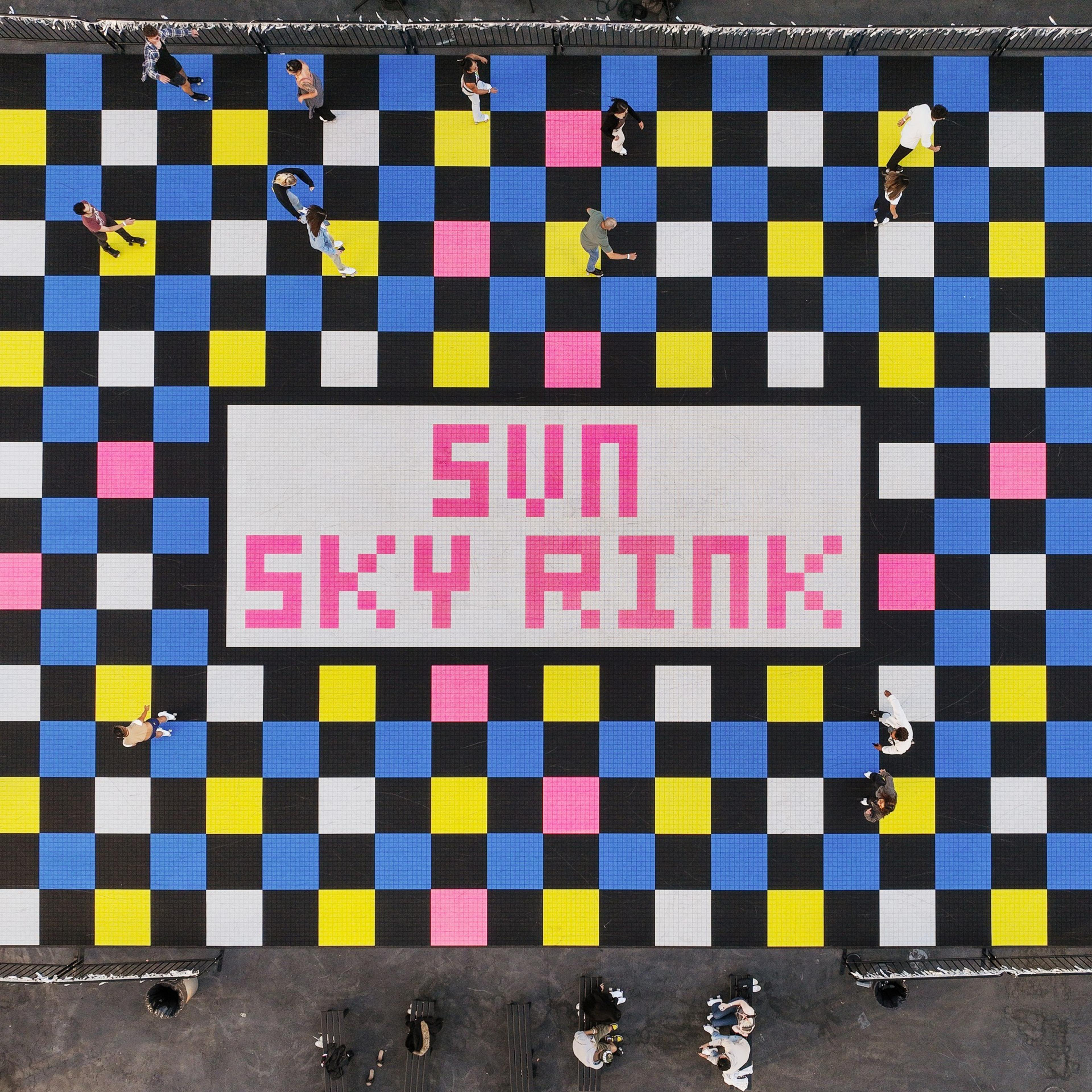 The image shows a colorful checkered floor with blue, pink, yellow, black, and white squares, with people walking or standing on it. In the center, it says &quot;SUN SKY RINK&quot; in pink text.