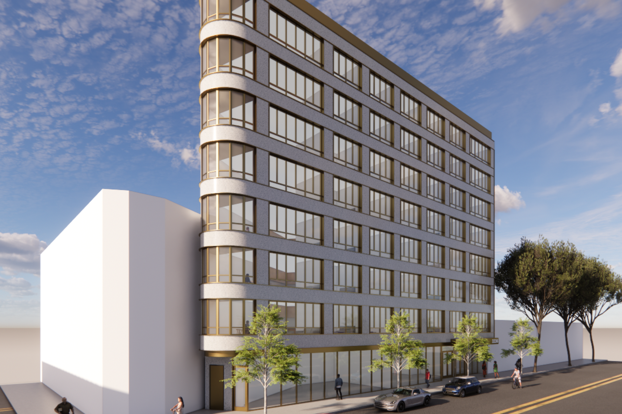A modern seven-story building with curved corners, large windows, and gold accents stands next to a white block-shaped structure on a street with cars and trees.