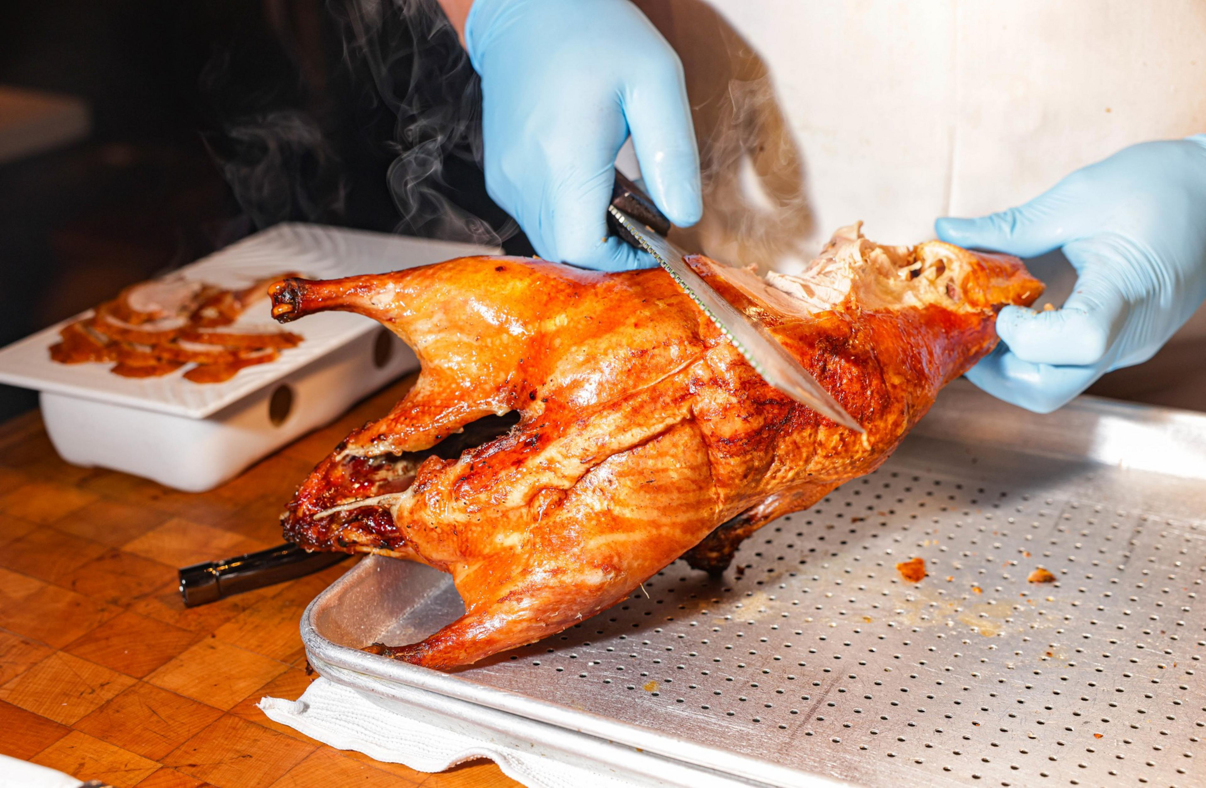 Man cutting a roasted duck