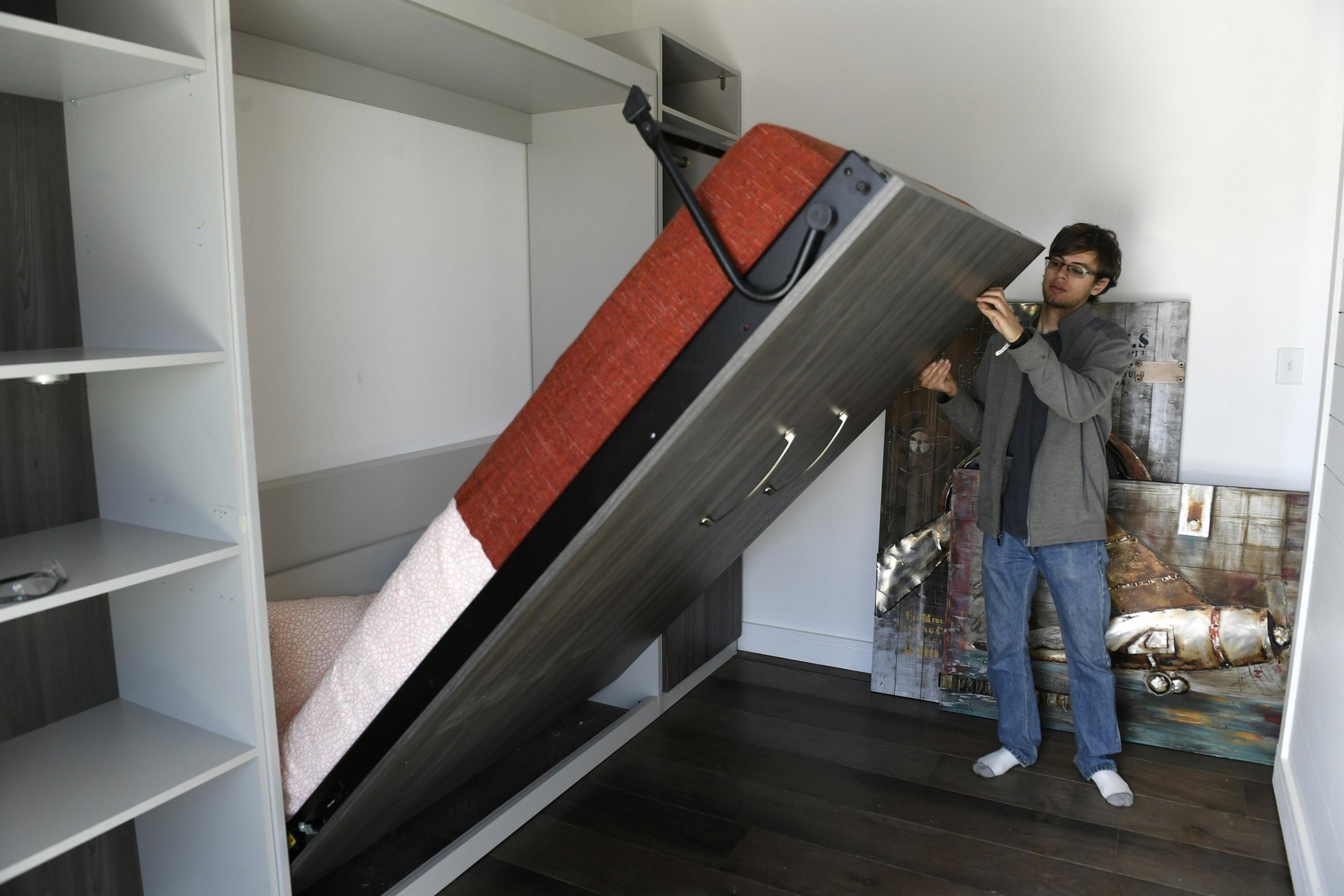 A person demonstrates how to use a Murphy bed