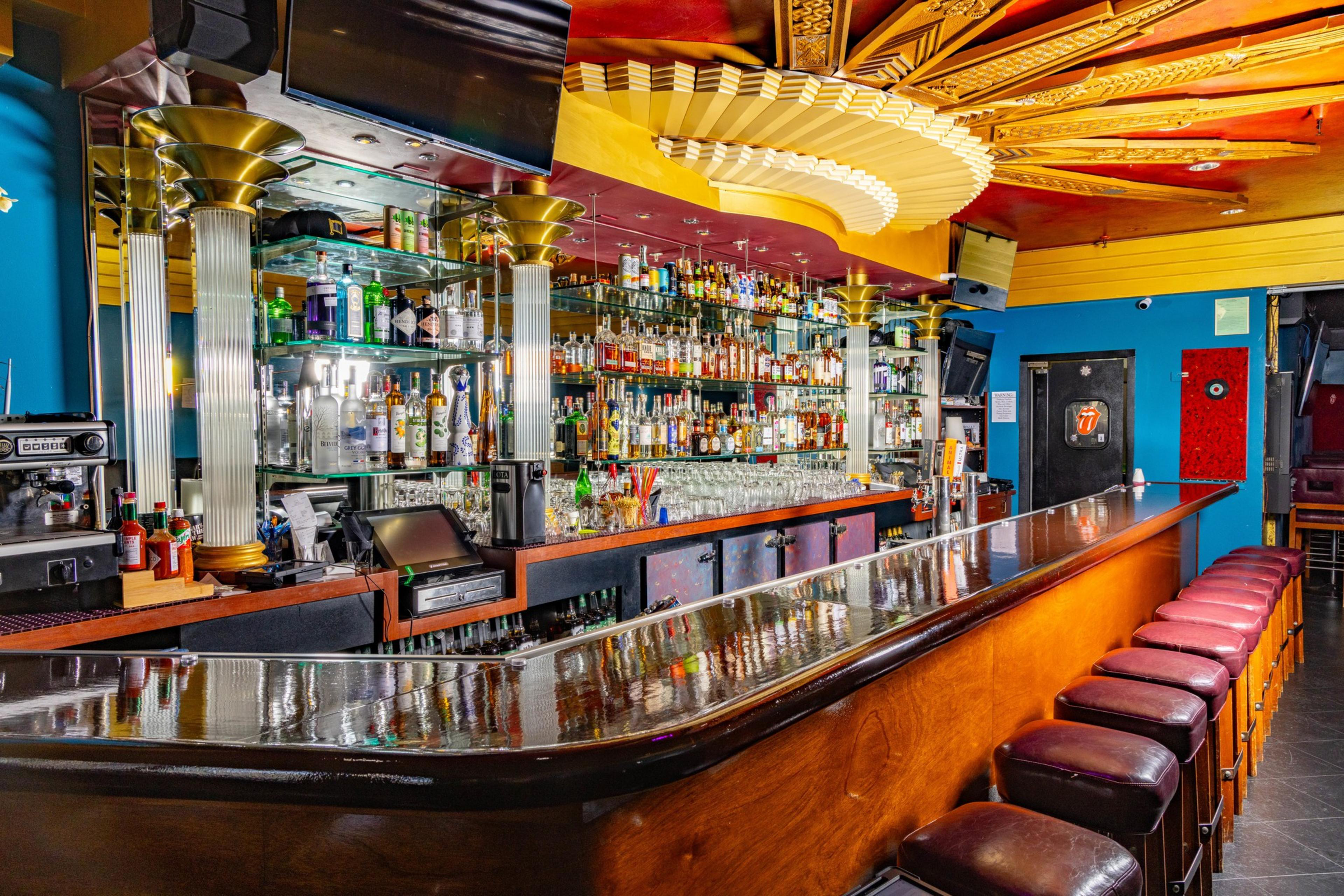A sun-motif ceiling fixture shines down over booths and a bar.