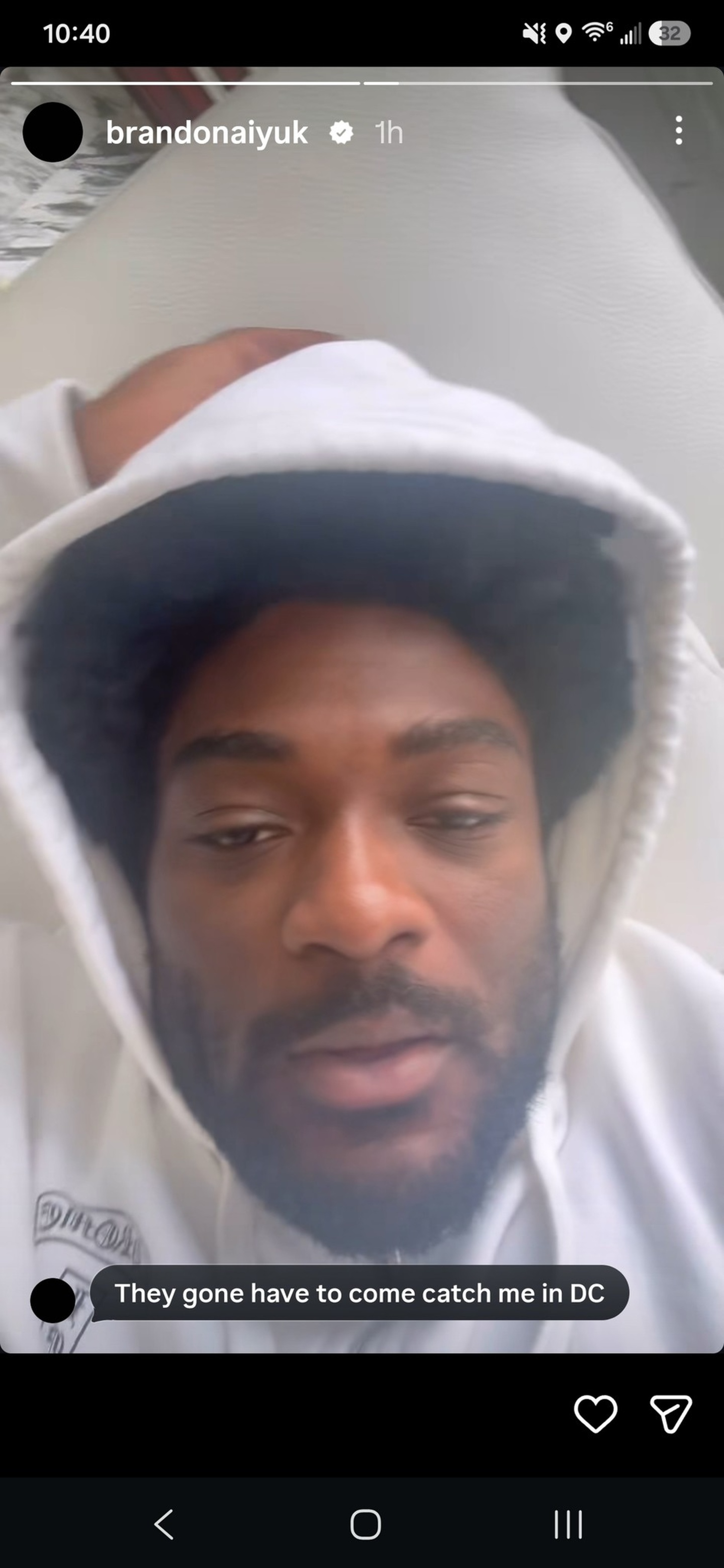 A man with a beard and mustache wears a white hoodie, lying down with the hood up, looking relaxed and slightly tired. Text overlay reads, “They gone have to come catch me in DC.”