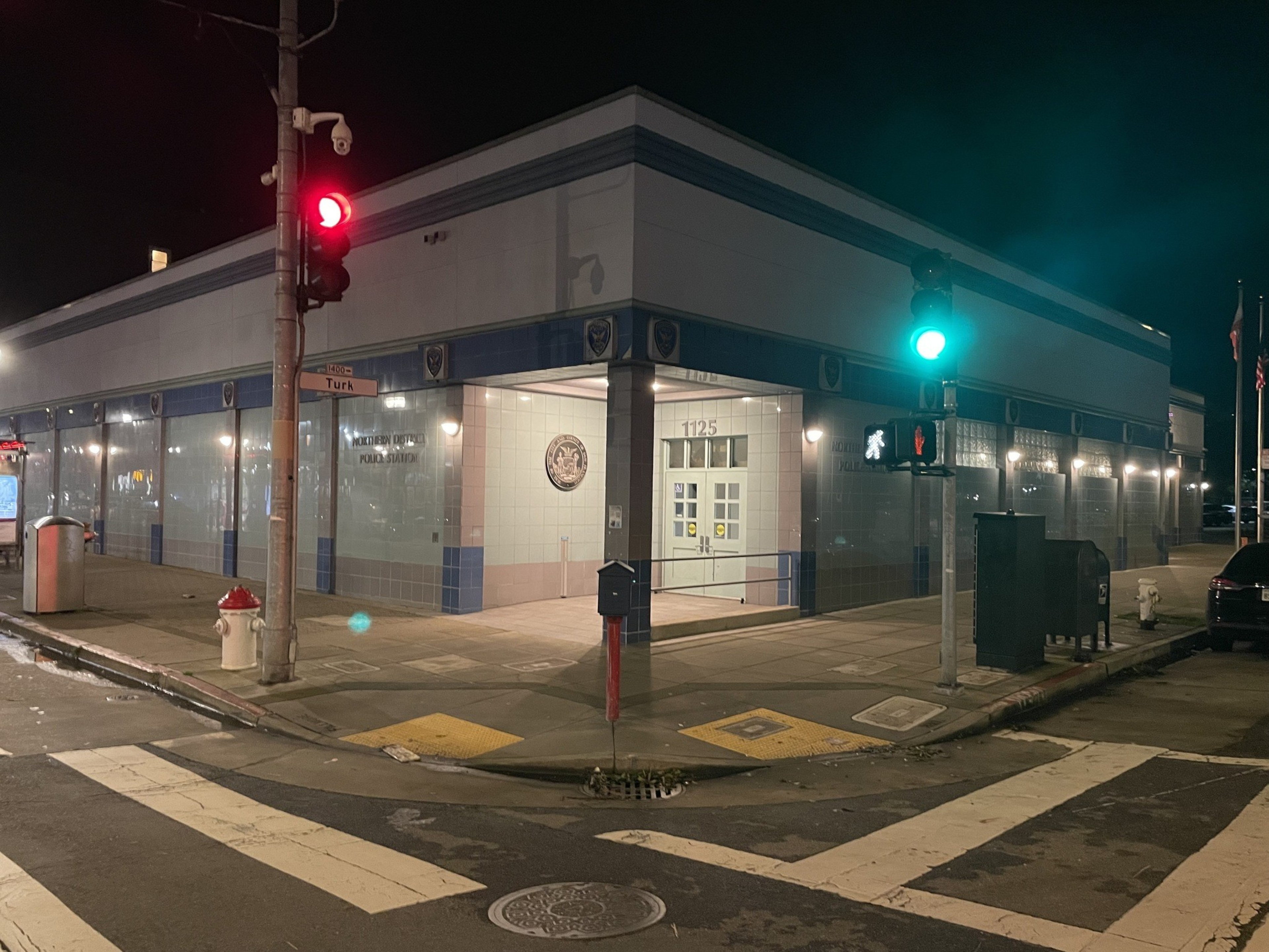 A police station is seen on a street corner.