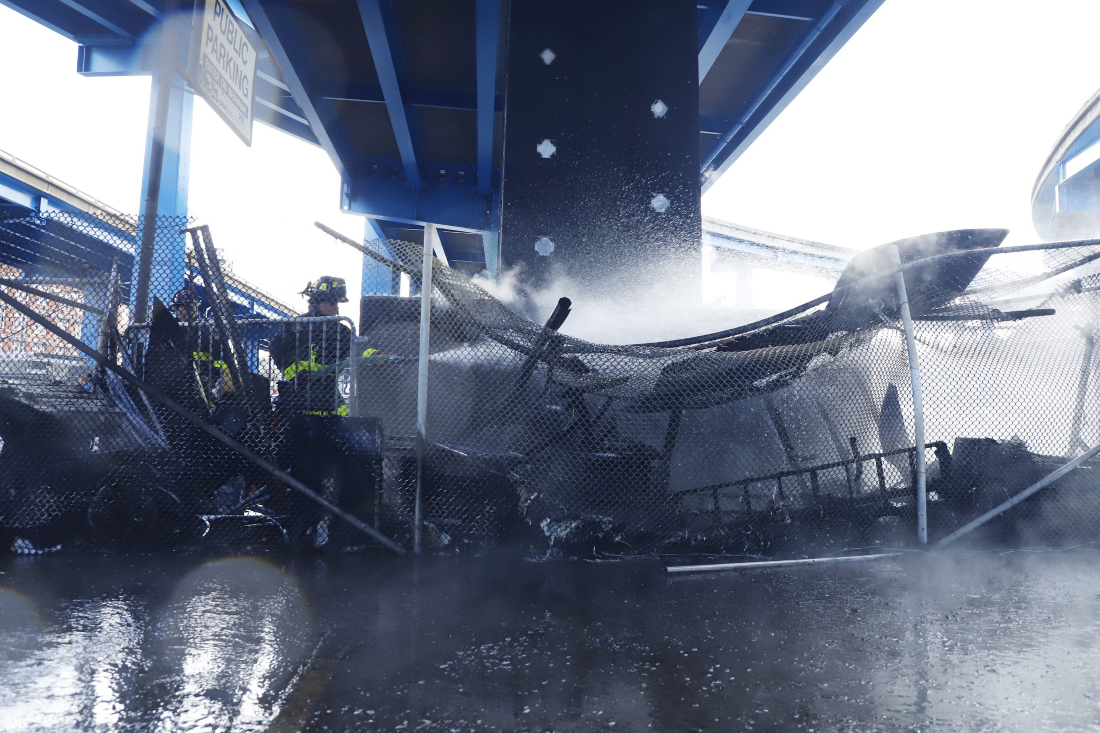 SFPD firefighters attempt to put out a homeless encampment fire in a CalTrans parking lot on Division Street.
