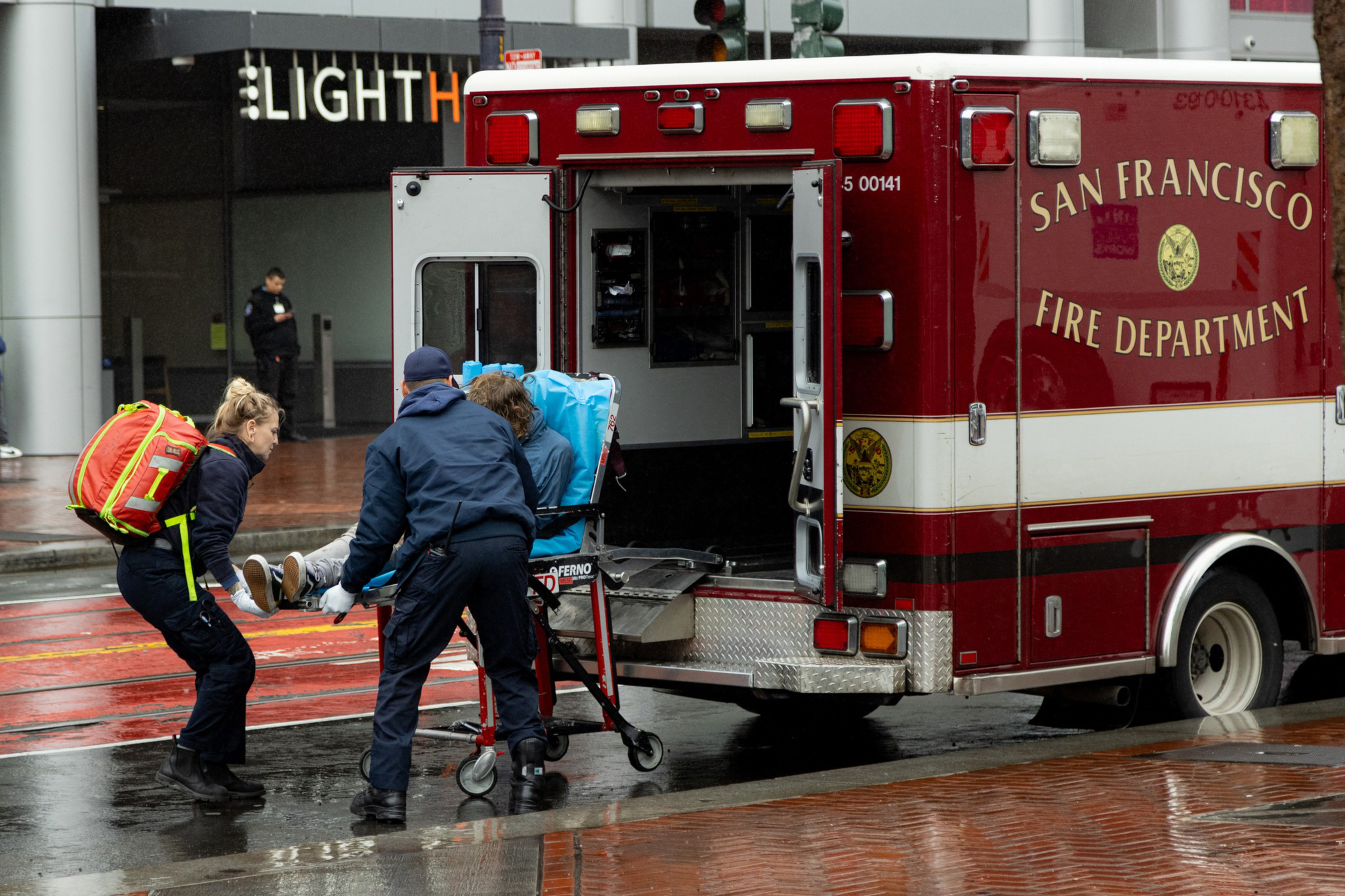 Paramedics load a person on a stretcher into an ambulance labeled "San Francisco Fire Department."