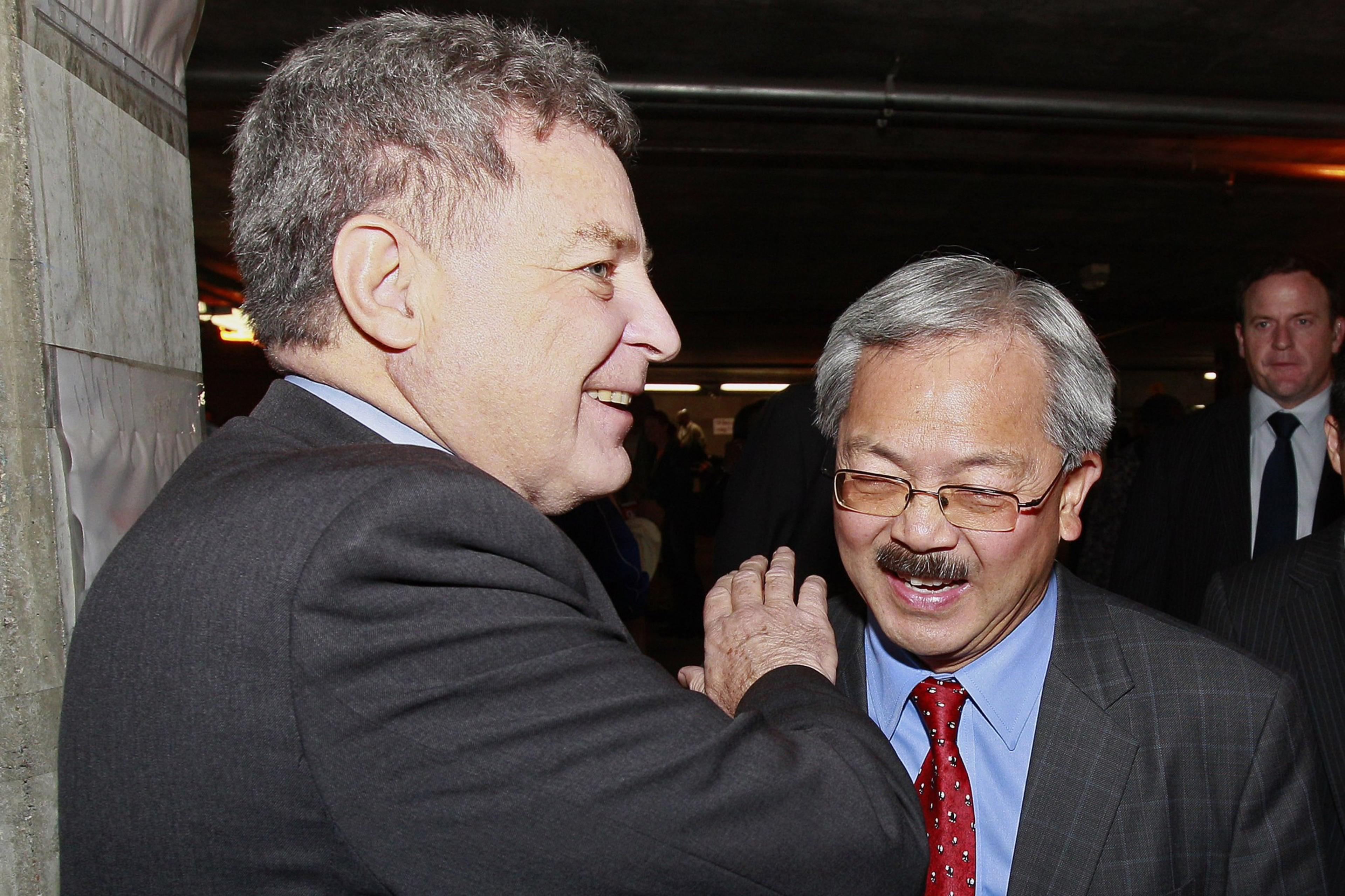 A man pats another man on the shoulder.