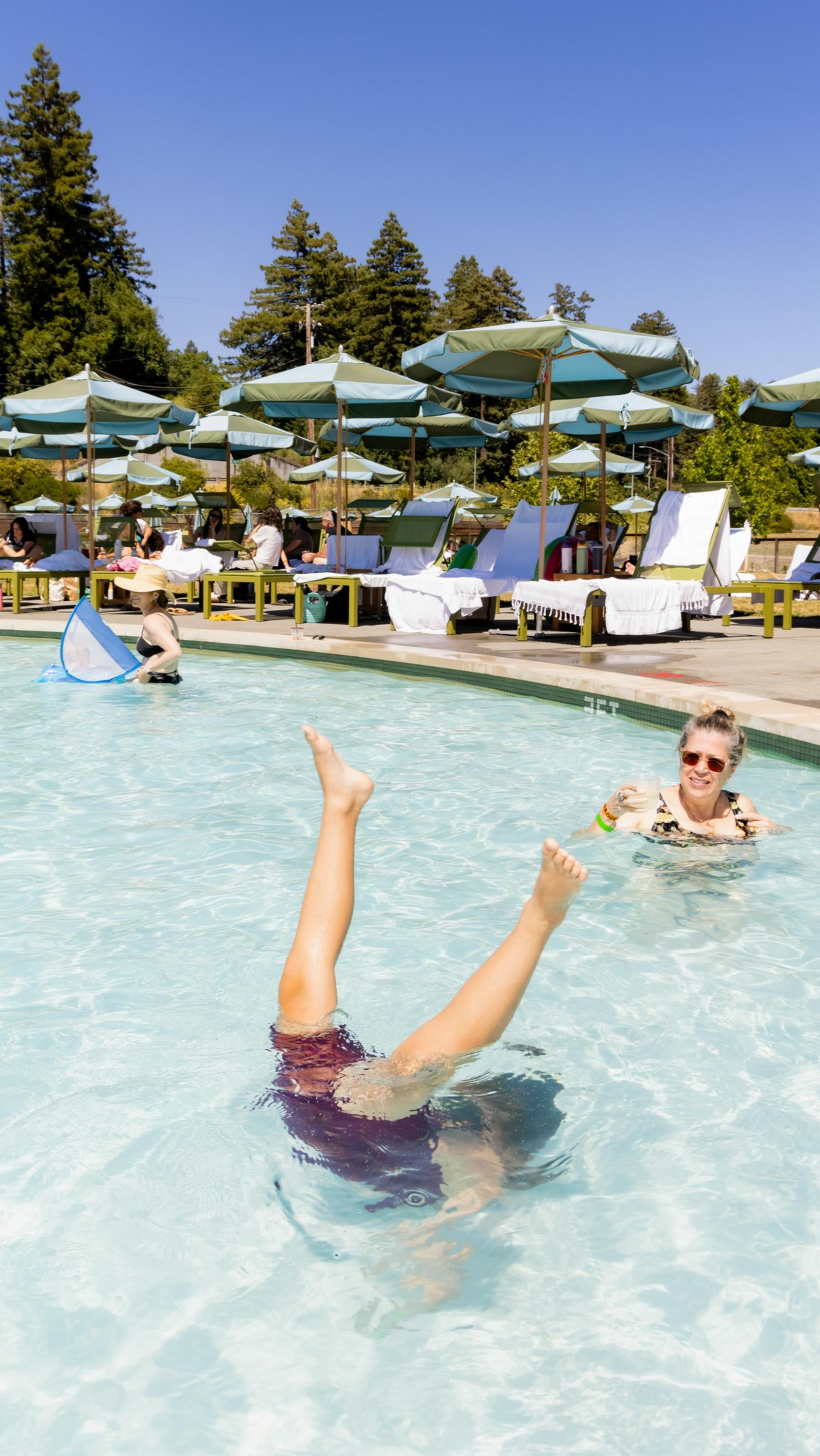Kid doing a handstand in The River Electric pool