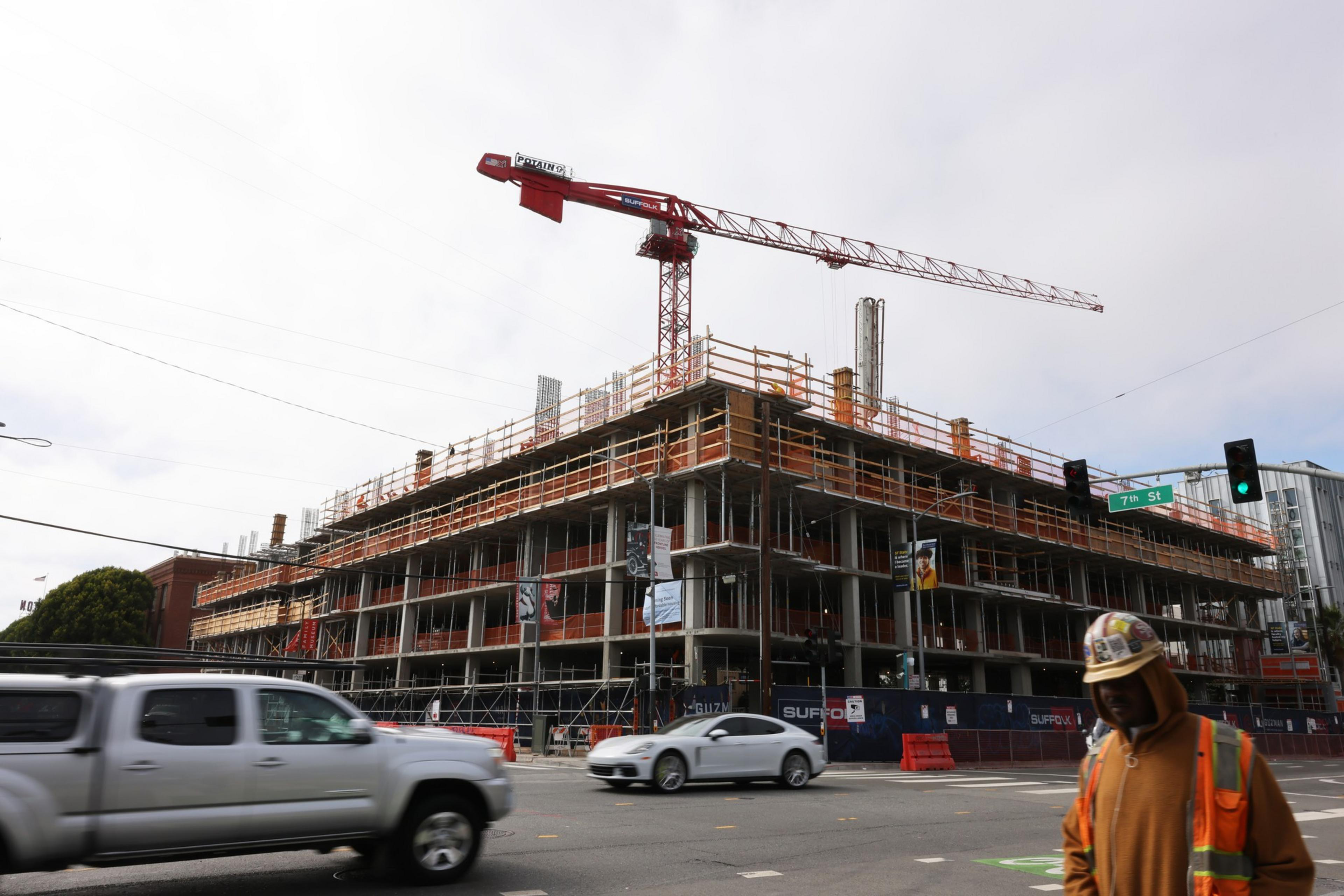 Pedestrian and vehicles pass a construction site.